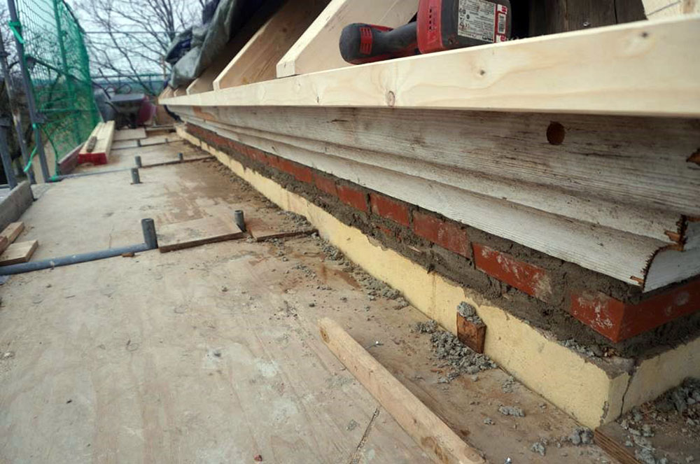 Bild 15 | neu ausgemauerter Spalt unterhalb profiliertem Traufgesims, darüber neu ausgebildete Dachtraufe mit neu hergestellten und aufgebrachten Aufschieblingen
